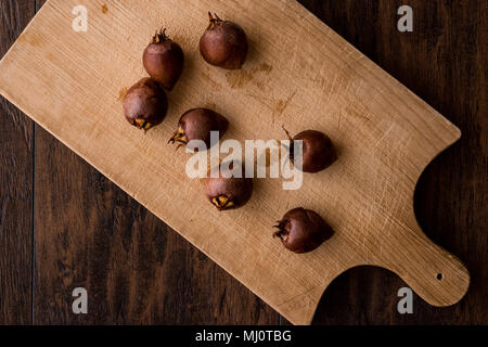 Nespola frutti su una superficie di legno. (Concetto organico) Foto Stock