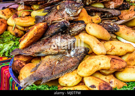 La frittura di pesce e patate su strada il cibo in stallo durante il gigante kite festival il giorno di Ognissanti, Santiago Sacatepequez, Guatemala Foto Stock