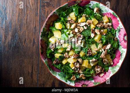 Ananas con insalata di verdure su una superficie in legno. Alimenti biologici. Foto Stock