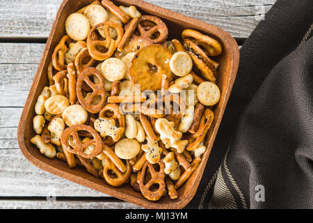 Miscelati snack salato di cracker e salatini nella ciotola. Foto Stock