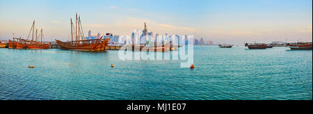 Panorama del Porto di Doha al mattino - il dhow barche sono ormeggiate e attendere per le escursioni, i grattacieli sono nella luce di haze e la superficie dell'acqua è Foto Stock