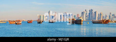 Panorama del Golfo Persico con numerosi dhow di legno navi e barche ormeggiate nel porto di Doha, il moderno quartiere degli affari è visto sullo sfondo, Qata Foto Stock