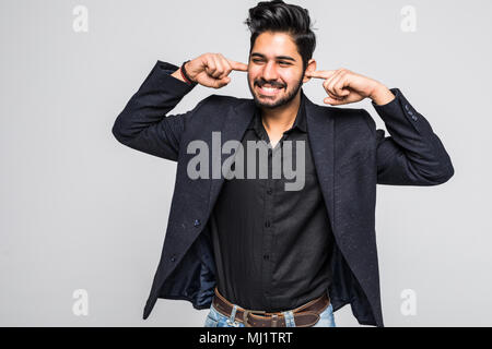 Bel giovane uomo indiano coperto i suoi orecchi da lui è il dito e urlando, egli non può stare il rumore, isolato su bianco Foto Stock