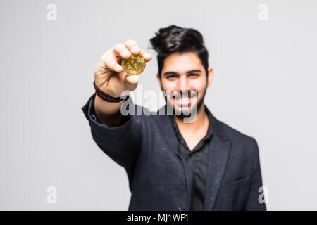 Successo uomo indiano in tuta rivolta f golden bitcoin isolato su bianco Foto Stock