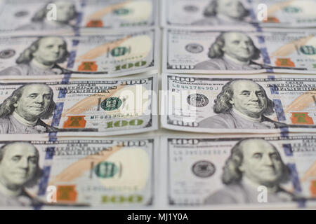 Sfondo della vista ravvicinata di centinaia di dollari di banconote, file di pile di dollari in centinaia di dollari di banconote sul tavolo bianco. Foto Stock