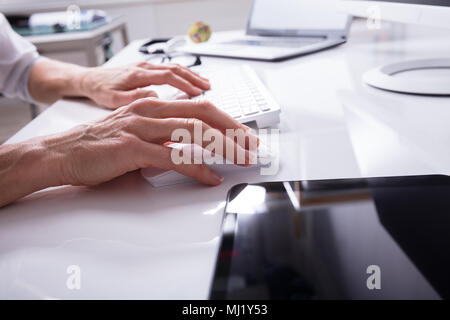 Close-up di un imprenditore la mano digitando sulla tastiera del computer Foto Stock