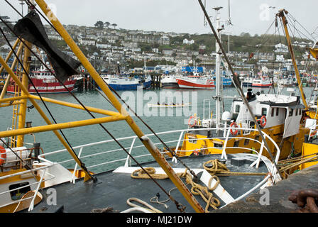 Sfogliare in primo piano con il tradizionale concerto pratica dietro e più colorate barche da pesca e la città di Newlyn in background. Foto Stock