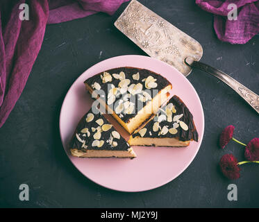 Pezzi di cheesecake con il cioccolato su una piastra di rosa, vista dall'alto, tonificazione vintage Foto Stock