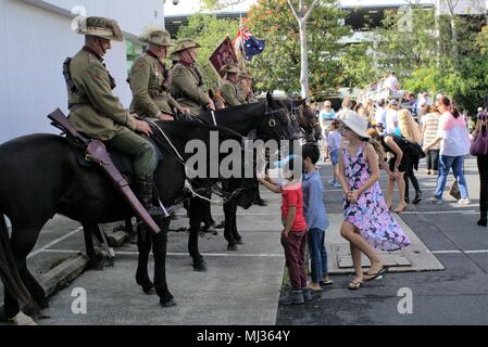 I bambini giocano intorno veterani montato sul dorso del cavallo per onorare i soldati di Australia e Nuova Zelanda esercito in Coffs Harbour Anzac Day Parade Foto Stock