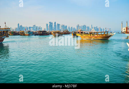 DOHA, Qatar - 13 febbraio 2018: i numerosi vecchi dhow di legno sono ormeggiati in porto, questa flotta turistica attrae persone di godere di escursioni in mare, su Februar Foto Stock