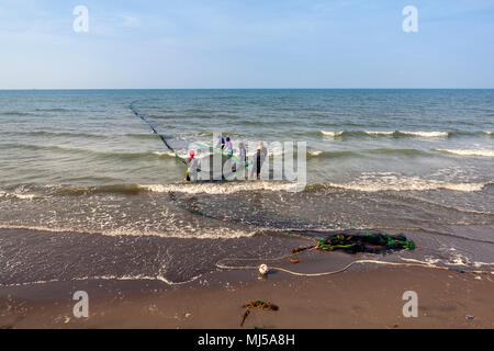 I pescatori lavorano in modo cooperativo posa e trasporto nel loro vicino a miglio lungo Senna net a Roxas City, Panay Island, Filippine. Foto Stock