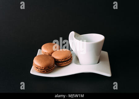 Set di tazza di caffè e amaretti su sfondo nero. Messa a fuoco selettiva Foto Stock
