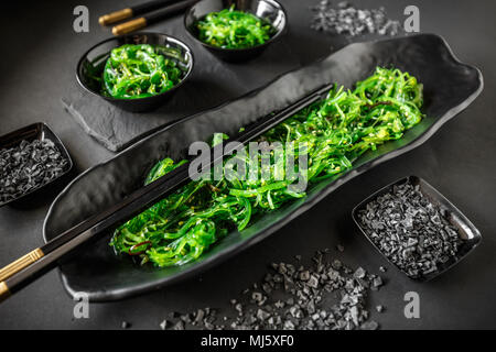 Alghe Wakame insalata servita sulla tradizionale cibo giapponese su nero piatto  di ceramica Foto stock - Alamy