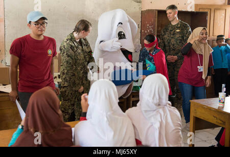 BENGKULU, Indonesia (Aprile 06, 2018) pacifico accordo di partenariato 2018 (PP18) salute dentale mascotte "Toothy" e "Captain pulire" dimostrare la salute dentale delle pratiche per gli studenti di SDN 77 Scuola Elementare di Bengkulu, Indonesia. PP18's missione è lavorare collettivamente con host e nazioni partner per migliorare l'interoperabilità a livello regionale di emergenza e capacità di risposta, aumentando la stabilità e la sicurezza nella regione e favorire la nascita di nuove e durature amicizie in tutta la regione Indo-Pacifico. Pacific Partnership, ora nel suo tredicesimo iterazione, è la più grande multinazionale annuale di assistenza umanitaria e disast Foto Stock