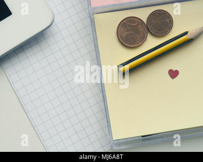 Sticky Notes con una matita di piccole dimensioni e la forma di cuore su un tavolo per ufficio Foto Stock
