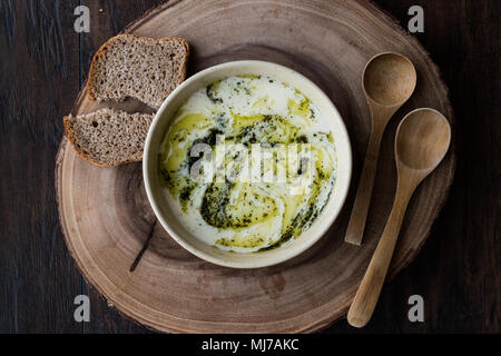 Yayla turco o zuppa di yogurt con salsa alla menta (Tzatziki) su una superficie di legno Foto Stock