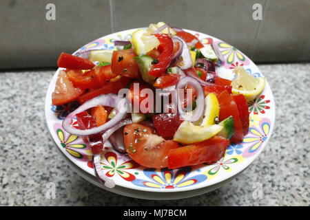 Appetitose insalate vegetariana da mature colorato succosa di pomodoro, cipolla rossa, il cetriolo, la crosta paprica dolce sotto piccante e l'olio d'oliva giaceva su piastra di porcellana Foto Stock