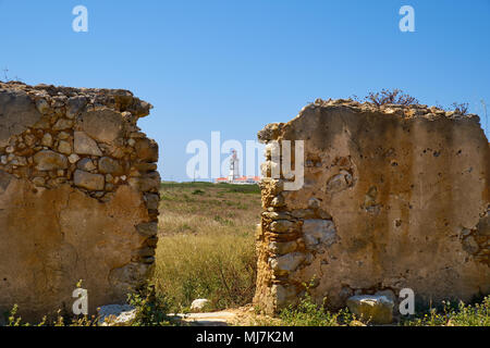 La vista di un faro attraverso un passaggio in un vecchio muro di mattoni di Cape Espichel a Sesimbra, Portogallo Foto Stock