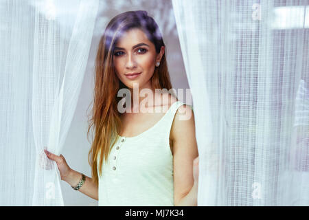 Donna attraente tende di apertura Foto Stock