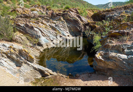 L'acqua stagnante isolato in pietra bagno costituito dal flusso d'acqua. Pulo do Lobo, Guadiana River Valley Natural Park, Alentejo, Portogallo. Foto Stock