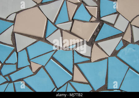 Sfondo con rotte mosaico di piastrelle in colori blu e beige sulla facciata esterna di un edificio. Foto Stock