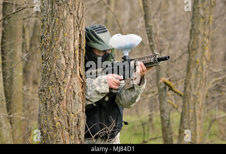 Il paintball player sotto attacco nella foresta Foto Stock