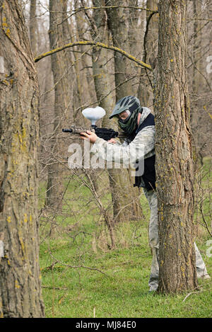 Il paintball player sotto attacco nella foresta Foto Stock