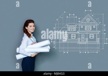 Allegro architetto sorridere mentre trasportano importanti graphics Foto Stock