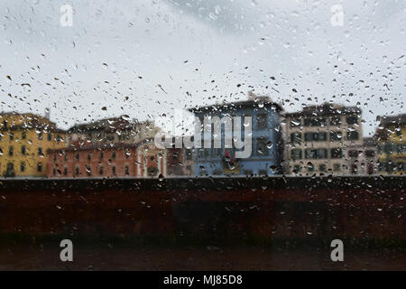 Pisa, Italia in un giorno di pioggia. Vista attraverso un lato umido finestra auto per il viale principale di Pisa accanto al fiume Arno Foto Stock