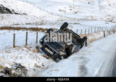 4x4 car si è schiantato in una fossa nella neve su una strada principale Foto Stock