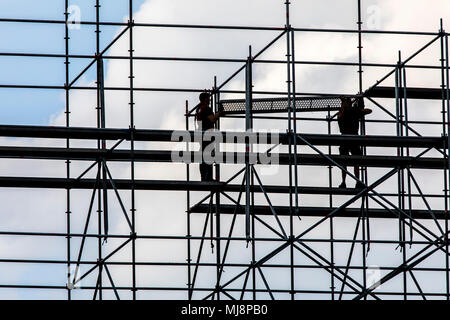 Ponteggio builder durante lo smantellamento di un grande, free-standing impalcature, Foto Stock