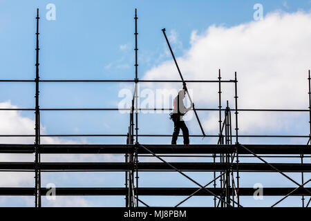 Ponteggio builder durante lo smantellamento di un grande, free-standing impalcature, Foto Stock