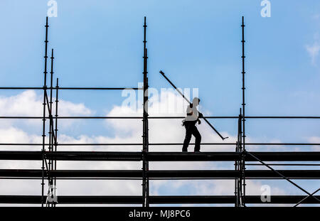 Ponteggio builder durante lo smantellamento di un grande, free-standing impalcature, Foto Stock