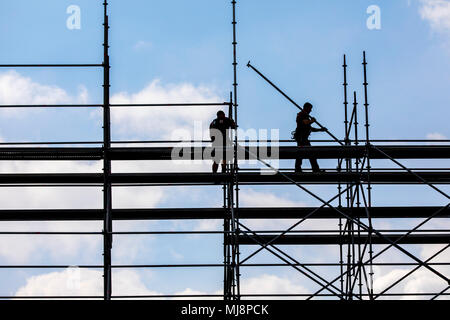 Ponteggio builder durante lo smantellamento di un grande, free-standing impalcature, Foto Stock