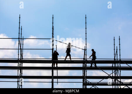 Ponteggio builder durante lo smantellamento di un grande, free-standing impalcature, Foto Stock