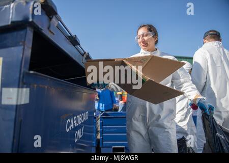 180419-N-DA-737-0180 Everett, Washington (19 aprile 2018) Da elettricista, Mate Fireman Stefany Canales, da Atlanta, Georgia, assegnato alla stazione navale di Everett (NSE), ricicla cartone durante un giorno di terra dumpster dive evento tenutosi su NSE. La Giornata della Terra è celebrata ogni anno in tutto il mondo a dimostrare il supporto per la protezione ambientale, con velisti assegnati NSE e visite-missile destroyer USS Kidd (DDG 110) partecipano all'evento. (U.S. Foto di Marina di Massa lo specialista di comunicazione 2a classe Jonathan Jiang/rilasciato) Foto Stock