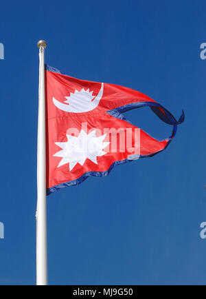 La bandiera nazionale del Nepal sul cielo blu. Foto Stock