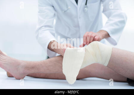 Medico del bendaggio del ginocchio del paziente Foto Stock