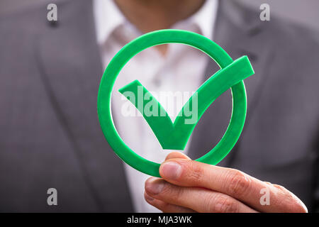 Close-up di un imprenditore di mano azienda Icona segno di spunta verde Foto Stock