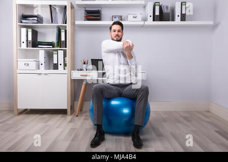 Imprenditore seduti sulla palla Fitness Ginnastica Foto Stock
