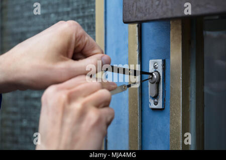 Close-up di mano di una persona porta di apertura con Lockpicker Foto Stock