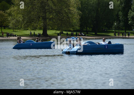 Persone in barche a pedali sulla serpentina in Hyde Park, Londra come i britannici sembrano godere di una molla canicola, con lunedì festivo previsioni per essere il più caldo di sempre. Foto Stock
