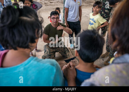 Stati Uniti Navy Corpsman ospedale di terza classe Simon Rodriguez spiega come eseguire le compressioni toraciche durante una cooperativa impegno sanitario a sostegno dell'esercizio Balikatan Calangitan presso la scuola elementare nel Capas, Tarlac, Filippine, 23 aprile 2018. Rodriguez è una medicina preventiva tecnico sanitario con 3° Battaglione medica, 3° Marine Logistics Group ed è un 21-anno-vecchio nativo di Chicago, Illinois. Balikatan 34-2018, nella sua trentaquattresima iterazione è un annuale U.S.-militari filippini esercizio di formazione incentrati su una varietà di missioni, comprese la fornitura di assistenza umanitaria e di soccorso in caso di catastrofe, counte Foto Stock