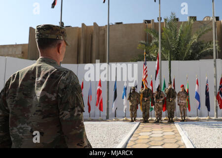 Il Mag. Gen. Walter Piatt, comandante della produzione combinata di forze congiunte terra comando di componente, osserva la guardia di colore durante la disattivazione CJFLCC cerimonia a Baghdad, Iraq, 30 aprile 2018. La disattivazione significa la fine delle principali operazioni di combattimento contro ISIS in Iraq e riconosce il cambiamento di composizione e le responsabilità della coalizione. (U.S. Foto dell'esercito da Master Sgt. Orazio Murray) Foto Stock