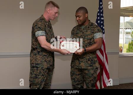 Col. Russell Burton, sinistra, comandante, Marine Corps Air Station New River, presenta un premio a Sgt. Tevin Jester, centro di lavoro supervisore, Marine Aircraft Group 26, II Aeromobili Marina Wing, durante le elezioni presidenziali riconoscimenti e apprezzamento di volontariato cerimonia su Marine Corps Air Station New River, N.C., 26 aprile 2018. Lo scopo di questa cerimonia è stato in onore di Marines e membri della famiglia per il loro ampio servizio comunitario di 100 ore o più. (U.S. Marine Corps photo by Lance Cpl. Ursula V. Smith) Foto Stock