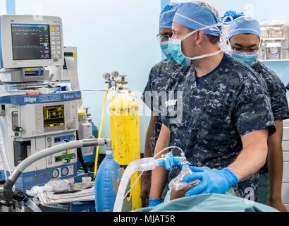 180430-N-RM689-0039 Trincomalee, Sri Lanka (30 aprile 2018) lo staff chirurgico assegnati ai militari di comando Sealift nave ospedale USNS misericordia (T-AH 19) per Pacific Partnership 2018 (PP18) e dello Sri Lanka professionisti medici amministrare anestesia durante un femore distale riduzione aperta per la fissazione interna a bordo di chirurgia misericordia durante lo Sri Lanka missione stop. PP18's missione è lavorare collettivamente con host e nazioni partner per migliorare l'interoperabilità a livello regionale di emergenza e capacità di risposta, aumentare la stabilità e la sicurezza nella regione e favorire la nascita di nuove e durature amicizie al di là della Indo-P Foto Stock