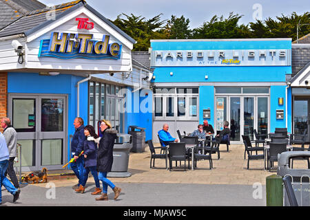 I villeggianti passeggiare tra le Hi-Tide inn & Harbour Lights Bar/divertimenti centro sul lungomare alla stazione balneare di Porthcawl. Galles del Sud. Foto Stock