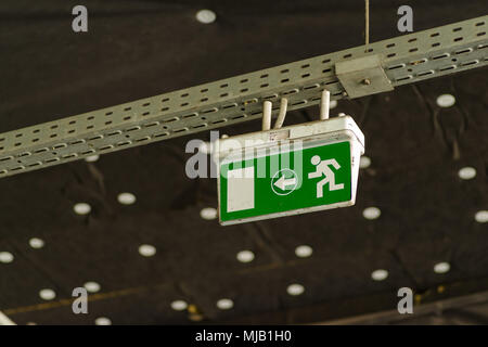 Uscita verde segno sospesi dal soffitto in un pubblico facilità di trasporto Foto Stock