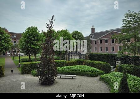 Amsterdam, Paesi Bassi: la facciata nord del Museo Hermitage sul fiume Amstel, vista dal giardino con un piccolo bambino camminando sul marciapiede. Foto Stock