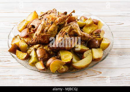 Quaglie al forno con patate in casa su una piastra Foto Stock